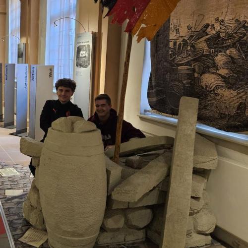 Schüler verstecken sich hinter Trümmern in der Ausstellung