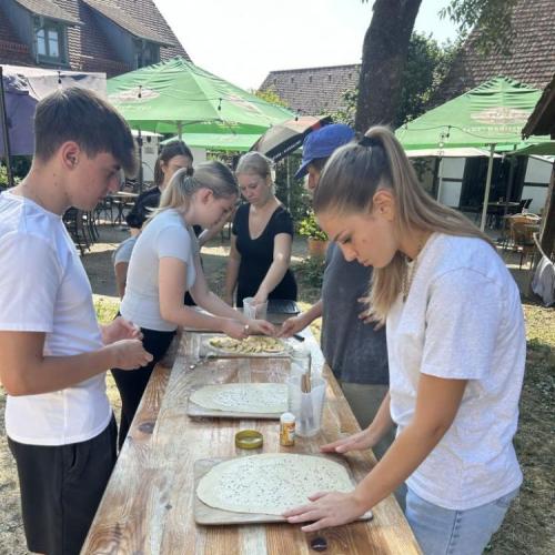Schüler:innen bereiten einen Flammkuchen vor