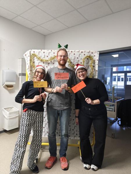 Lehrer:innen mit Schildchen wünschen ein frohes Fest